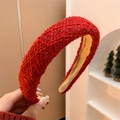 Close-up of red woven texture on a wide padded headband for festive winter hair styling - Festive Red