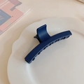 Detalle de una pinza de pelo mate azul marino grande en un plato decorativo de cerámica - Azul Real