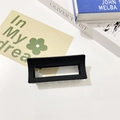 Detail of a large matte black rectangular hollow hair claw clip on a white table - Black