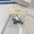 Vue détaillée de deux barrettes camélia vertes en résine avec perles blanches sur carte - Vert Perle