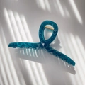 Detail shot of large translucent dark teal geometric faceted claw clip with gold spring - Transparent Blue Green