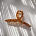 Macro shot of amber translucent hair claw clip with diamond grid pattern and golden spring - Icy Translucent Brown