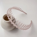 Pink frosted non-slip headband with teeth for women, displayed on a ceramic vase - Jelly Frosted Light Pink