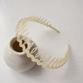 Minimalist beige wavy headband with long teeth for hair styling on a white ceramic vase - Matte Jelly Yellow
