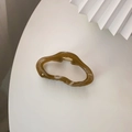 Detailansicht der bernsteinfarbenen Haarklammer in Wolkenform mit Goldfeder - Braun