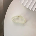 Nahaufnahme der cremefarbenen Haarklammer aus Harz mit minimalistischem Cut-out-Design - Weiß