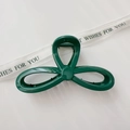 Macro view of a large dark green hair claw clip with a glossy triple-loop woven design - Glossy Green