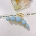 Detailed close-up of blue acrylic pearl hair claw clip with golden spring mechanism - Blue Five Beads