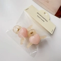 Detalle de dos pinzas para el cabello de corazón acrílico rosa con resortes dorados - Blanco Crema Gelatina