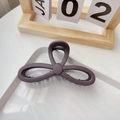 Detail of matte purple shark hair claw clip in a three-petal floral design on a tray - Matte Purple