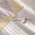 Detail of white iridescent cat hair clip with purple bow and sparkling glitter finish - Creamy White