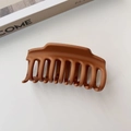 Detalle de una pinza de pelo grande en color caramelo mate sobre fondo blanco - Caramelo