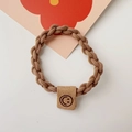 Detailed view of durable brown braided hair tie with a cute smiley face leather tag - Chain Style / Khaki