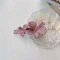 Détail d'une pince à cheveux papillon rose Morandi avec texture mate sur plateau - Papillon Rose Pâle