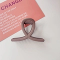 Detail view of a matte grey-purple cross-loop hair claw clip on a minimalist desk - Matte Light Coffee
