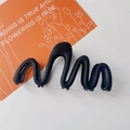 Makroansicht der mattschwarzen Haarklammer mit einzigartigem Wellenkurven-Design - Schwarz