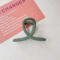 Detail view of the matte Morandi green twist hair claw clip on a white tabletop - Cross Shape / Matte Green