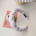 Detail shot of a white padded sponge headband with soft plush fabric and handmade label - White