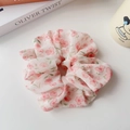 Dettaglio di un elastico per capelli in chiffon rosa con motivi floreali - Rosa