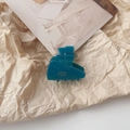 Detailed view of a dark teal acetate hair claw with gold Barrette la France lettering - Peacock Blue