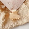 Detail of cream-colored geometric hair claw clip with Barrette la France lettering - Milky Yellow