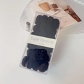 Dicke schwarze elastische Haargummis in klarer Aufbewahrungsbox auf einem Glastablett - Schwarz