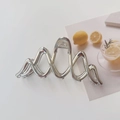 Dettaglio di un grande fermaglio per capelli in metallo argento con design geometrico - Argento