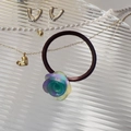Detail of elegant gradient purple rose hair tie on a decorative glass display plate - Multi-color