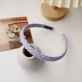 Detalle de diadema a cuadros azules con etiqueta hecha a mano sobre un jarrón blanco - Azul a Cuadros