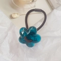 Detalle de un coletero con flores azules sobre un fondo blanco estético y elegante - Azul lago