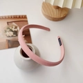 Detail of pink fabric headband with handmade tag in a minimalist home decor setting - Pink
