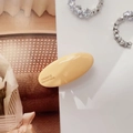 Detalle del clip ovalado de acrílico amarillo crema con texto de France Handmade - Amarillo