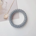 Detail of spiral hair tie featuring a retro black and white checkerboard pattern design - White Checkerboard