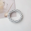 Detail shot of spiral hair tie featuring black heart patterns on a transparent base - White Heart