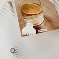Top view of a matte white mini hair claw clip for high ponytail styling on a warm card - Matte White