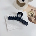 Dettaglio di un fermacapelli a fiori nero opaco con un elegante design a onde fiorite - Nero opaco