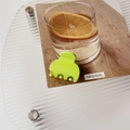 Close-up of neon green mini matte claw clip on a stylish transparent display stand - Matte Green