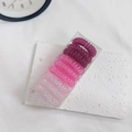 Close-up of nine spiral hair ties in gradient pink and purple tones in a transparent box - Gradient Pink