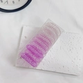 Detail view of 9 gradient purple spiral hair ties neatly packed in a clear storage box - Gradient Purple