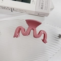 Vista detallada de una elegante pinza para el cabello rosa ondulada en bandeja de cristal - Pinza de Pelo en Forma de M Rosa Crema (23-03-28A)