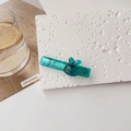 Detail of blue acrylic hair clip with a cute transparent rabbit motif on white background - Teal