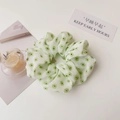 Close-up of white scrunchie with green floral pattern and soft pleated fabric texture - Green Flower