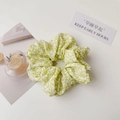 Detailed top view of a plaid fabric scrunchie with yellow and green floral patterns - Yellow Green Floral