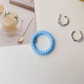 Blue spiral phone cord hair tie and silver crystal hoop earrings on a clean white desk - Forest Blue