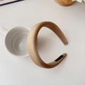 Dettaglio di un cerchietto in raso oro champagne con etichetta nera Hand Made - Marrone