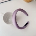 Detail of purple padded satin headband with Hand Made label on a ceramic cup - Purple