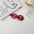 Close-up of matte vintage red infinity hair clip on white desk with aesthetic props - Infinity Matte Wine Red