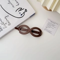 Detail view of a matte infinity loop hair clip in deep chocolate brown on a minimalist background - Infinity Matte Brown