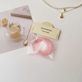 Detalle de gomas de pelo en espiral rosa en estuche con etiqueta de papel hecha a mano - Rosa transparente