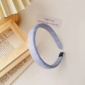 Detail of light blue ribbed fabric headband with soft wrapped ends and brand label - Fabric Headband / Blue